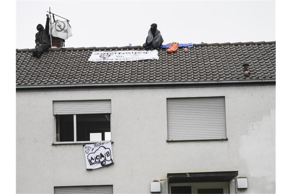 Polizei räumt Gebäude in Freiburg Zwei Aktivisten sitzen auf dem Dach einer ehemaligen Polizeiwache. Foto: Patrick Seeger/dpa