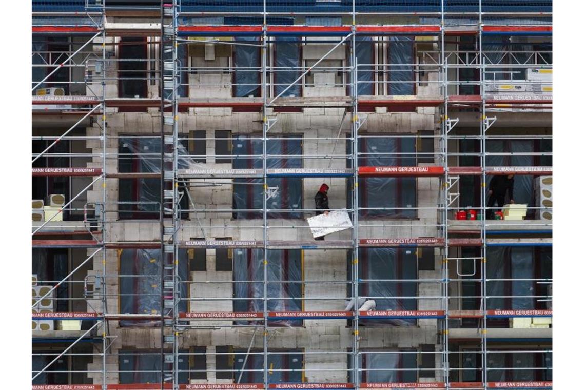 Zwei Arbeiter auf einem Gerüst von einem Wohnungsrohbau auf einer Baustelle. Foto: Soeren Stache/dpa-Zentralbild/dpa