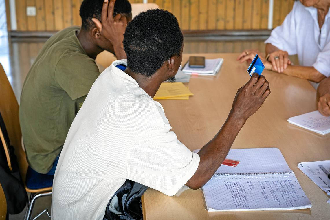 Zwei Asylbewerber berichten beim Arbeitskreis Asyl Backnang über die Probleme mit der Nutzung der Bezahlkarte. Foto: Alexander Becher