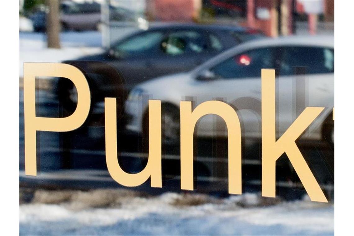 Immer mehr Baden-Württemberger sammeln Punkte in Flensburg Zwei Autos spiegeln sich im Schaufenster einer Fahrschule, auf der das Wort „Punkte“ zu sehen ist. Foto: picture alliance / dpa/Illustration