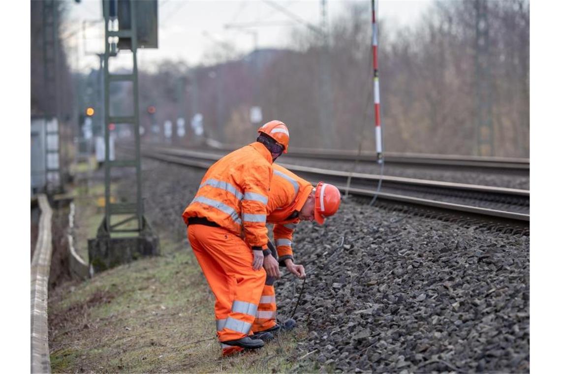 Zwei Bahnarbeiter untersuchen auf der Bahnstrecke zwischen Fürstenfeldbruck-Eichenau und München eine gerissene Leitung, die anschließend repariert wird. Foto: Peter Kneffel/dpa