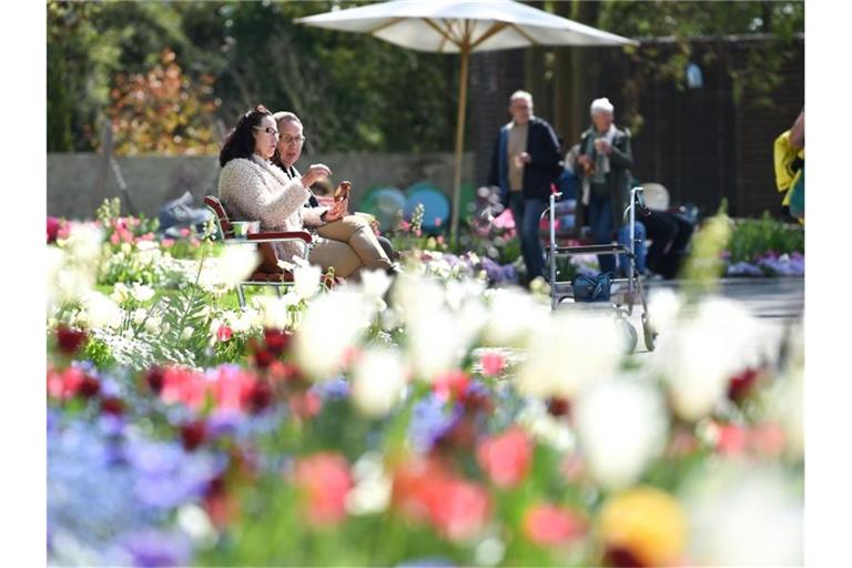 Zwei Besucher sitzen inmitten der Blumenpracht auf dem Gelände der Landesgartenschau in Überlingen. Foto: Felix Kästle/dpa/Archivbild