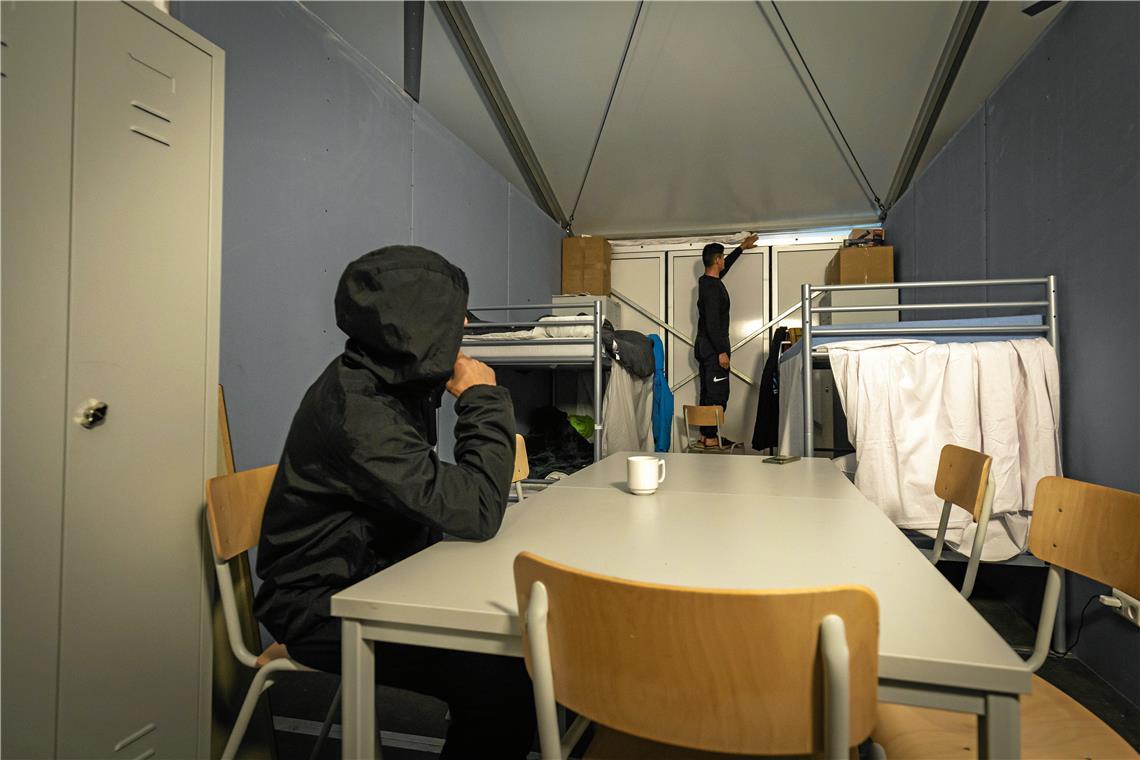 Heizungsausfälle in der Backnanger Zeltunterkunft Zwei Bewohner in ihrem Schlafraum in der Zeltunterkunft in Backnang: Um die kalte Luft draußen zu halten, haben sie ein Bettlaken zwischen die Decke und die Seitenwände gesteckt. Foto: Alexander Becher
