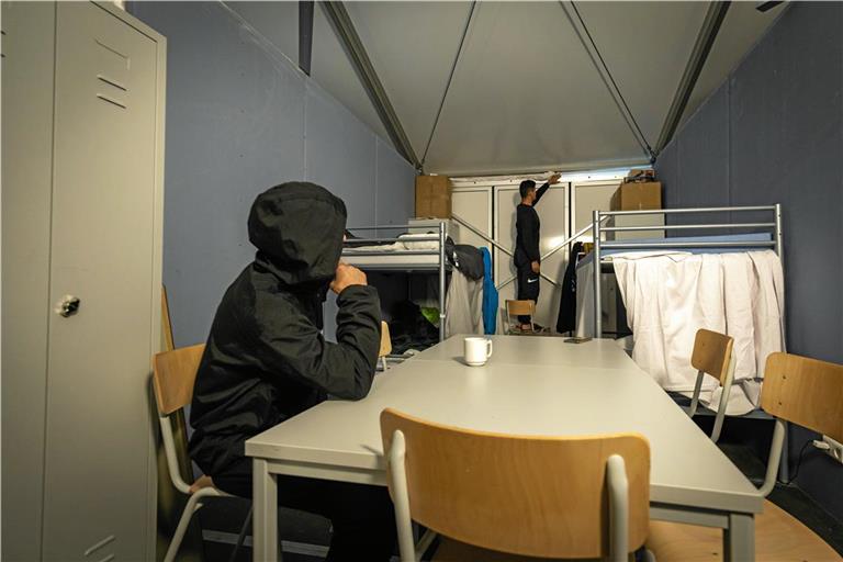 Zwei Bewohner in ihrem Schlafraum in der Zeltunterkunft in Backnang: Um die kalte Luft draußen zu halten, haben sie ein Bettlaken zwischen die Decke und die Seitenwände gesteckt. Foto: Alexander Becher