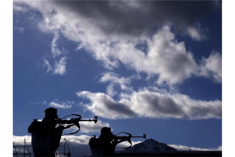 Zwei Biathleten in Antholz im Einzel über 20 Kilometer beim Schießen in Aktion. Foto: Matthias Schrader/AP/dpa