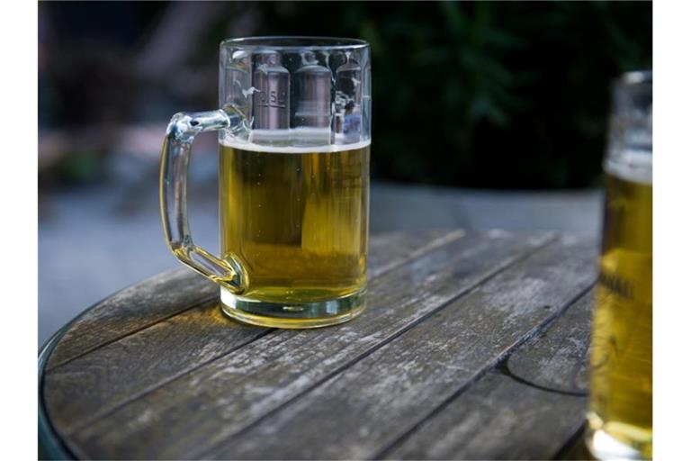 Zwei Bierkrüge stehen in einem Biergarten auf einem Tisch. Foto: picture alliance / dpa/Symbolbild