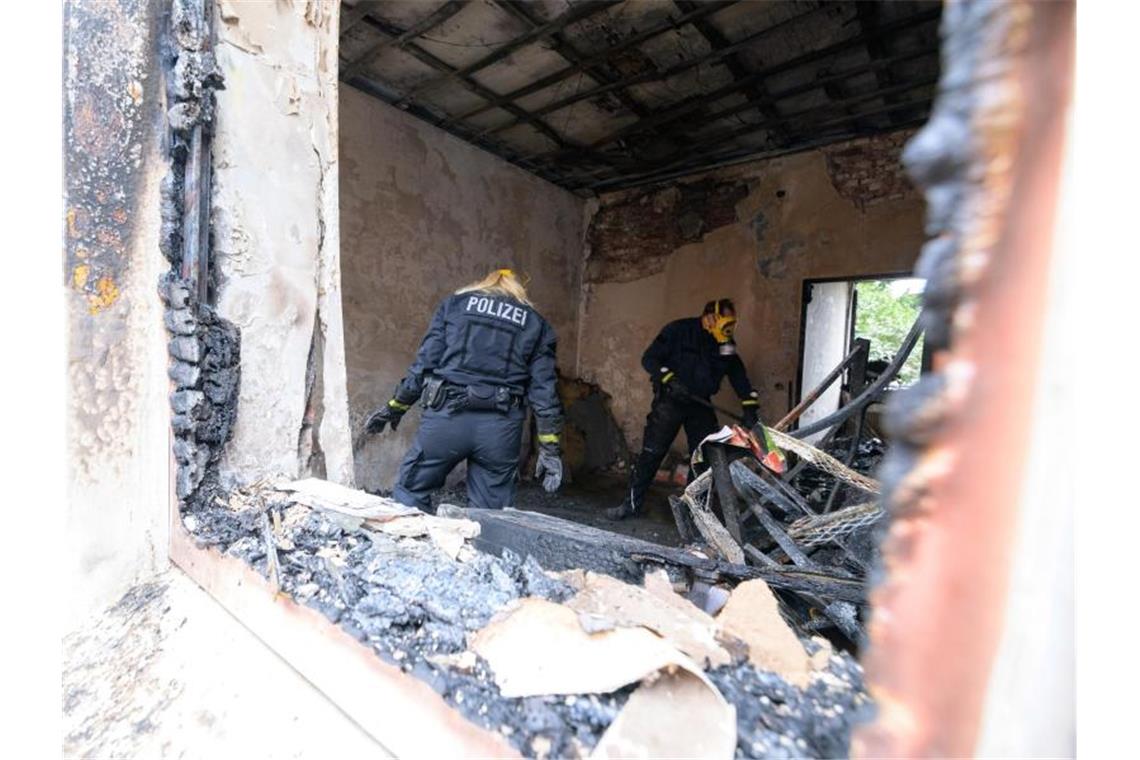 Zwei Brandermittler der Polizei im Einsatz. Foto: Jonas Walzberg/dpa