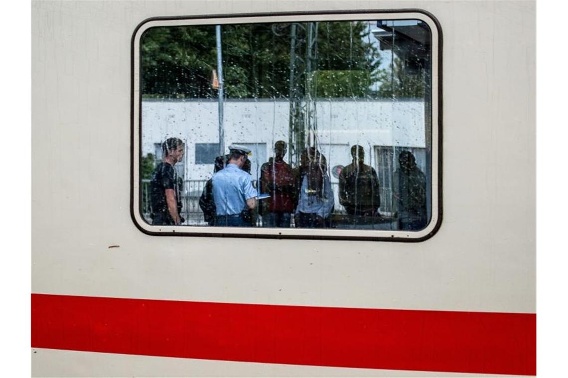 Weniger unerlaubte Grenzübertritte an EU-Außengrenzen Zwei Bundespolizisten nehmen auf einem Bahnhof in Bayern die Personalien von im Zug aufgegriffenen Flüchtlingen auf. Foto: Nicolas Armer/dpa/Archiv