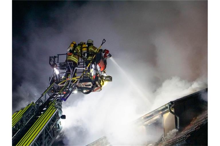 Zwei Feuerwehrkräfte am Brandort in Sachsenheim. Foto: Hemmann/SDMG/dpa