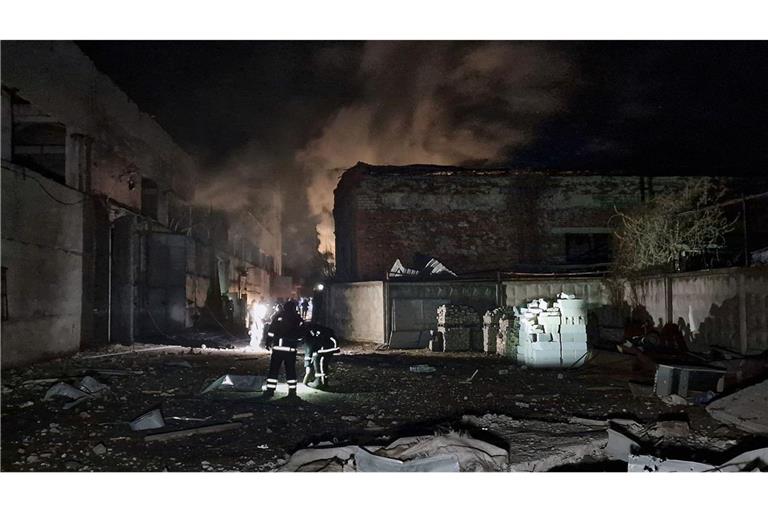 Zwei Feuerwehrleute stehen am Ort eines russischen Drohnenangriffs. (Archivbild)