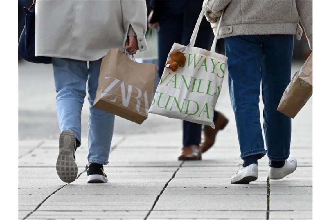 Zwei Frauen gehen mit Einkaufstüten über die Königstraße. Foto: Marijan Murat/dpa/Symbolbild