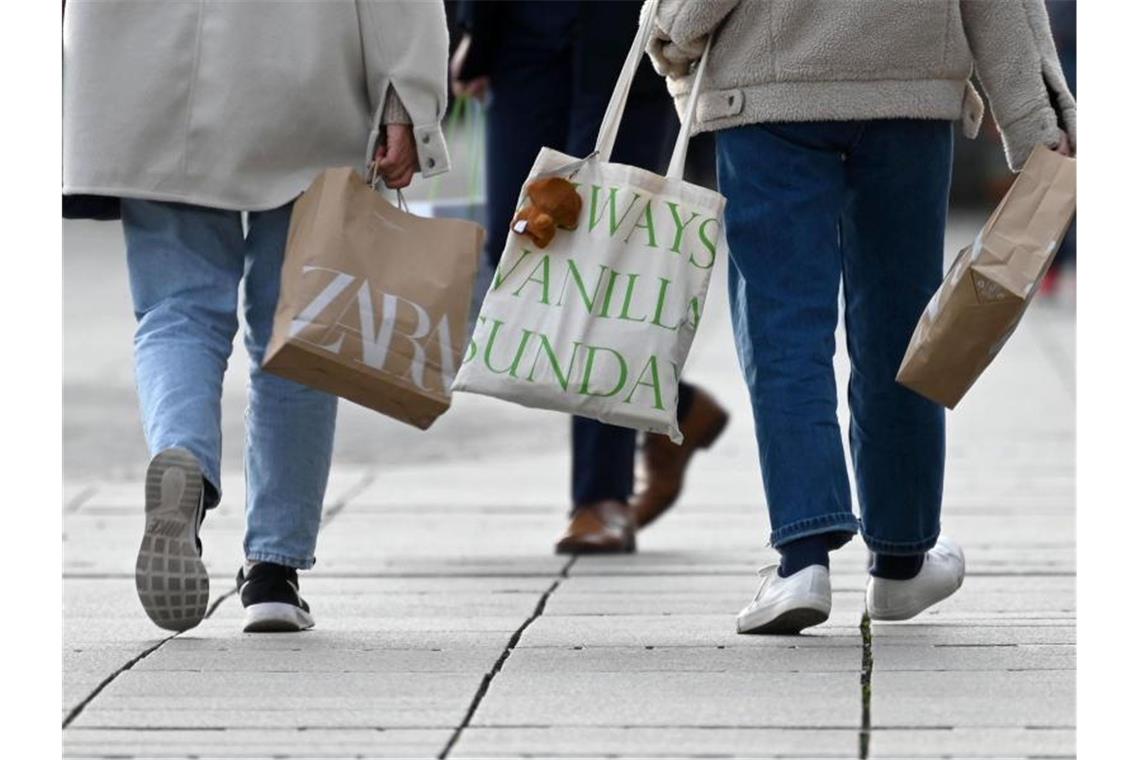 Zwei Frauen gehen mit Einkaufstüten über die Königstraße. Foto: Marijan Murat/dpa