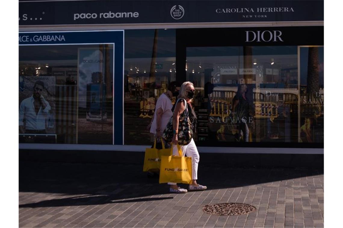 Zwei Frauen mit Mundschutz gehen in der Nähe von Playa Martinez in Santa Cruz de Tenerife shoppen. Auf den Kanarischen Inseln ist ein neuer Rekord an Neuinfektionen registriert worden. Foto: Arturo Jimenez/dpa