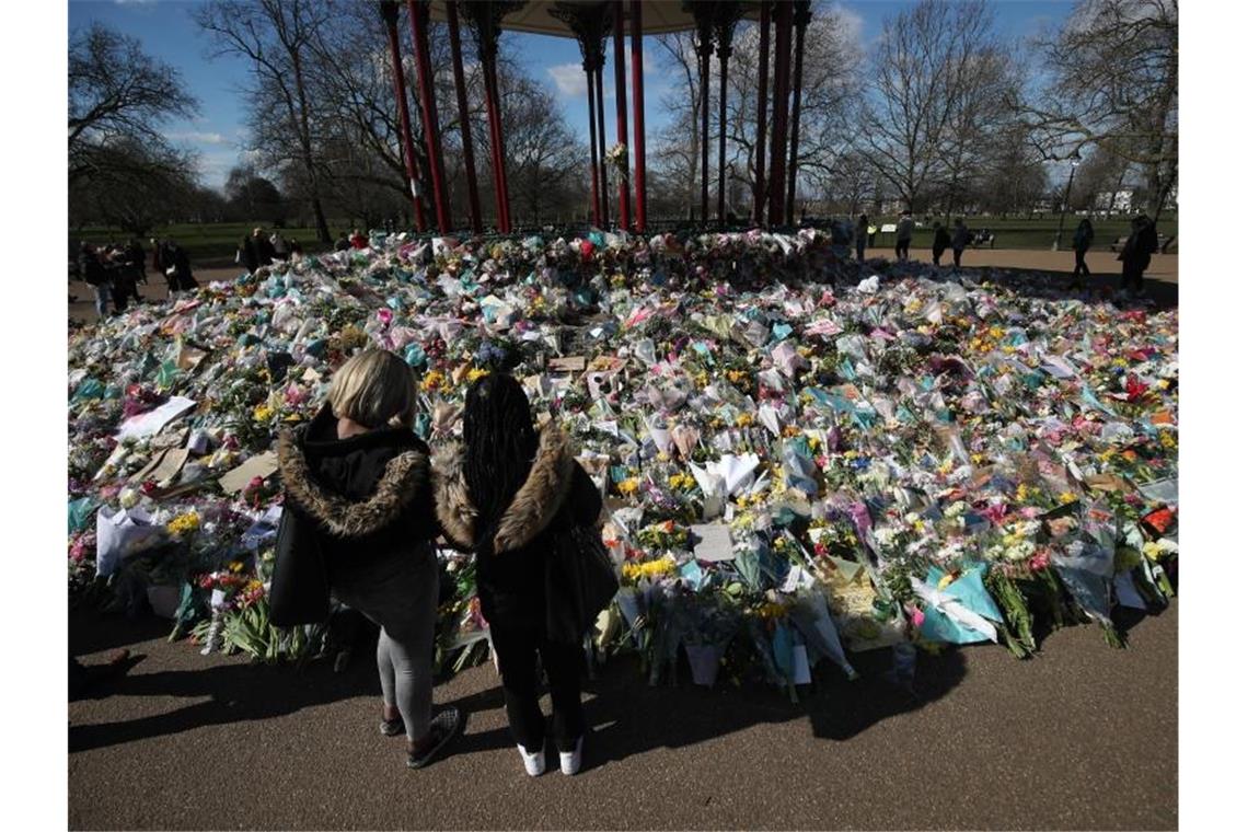 Drei Menschen in Nordirland tot aufgefunden Zwei Frauen schauen sich die Blumen an, die für die getötete Sarah Everard im Clapham Common Park in London niedergelegt wurden. Foto: Yui Mok/PA Wire/dpa
