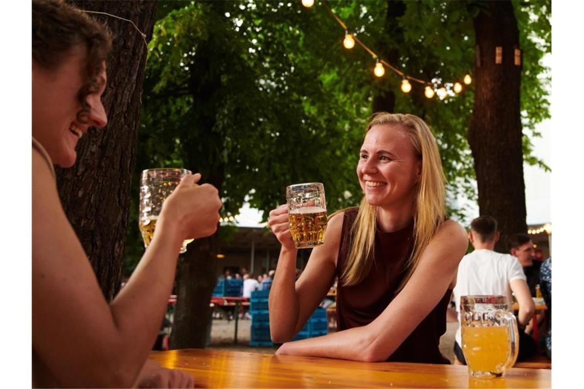 Zwei Frauen trinken ein Bier im Prater Biergarten in Berlin. Foto: Annette Riedl/dpa/Archiv