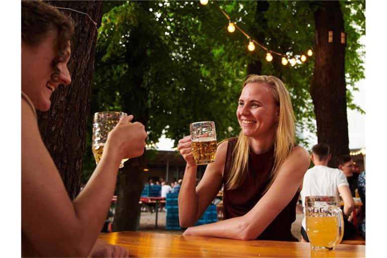 Zwei Frauen trinken ein Bier im Prater Biergarten in Berlin. Foto: Annette Riedl/dpa/Archiv