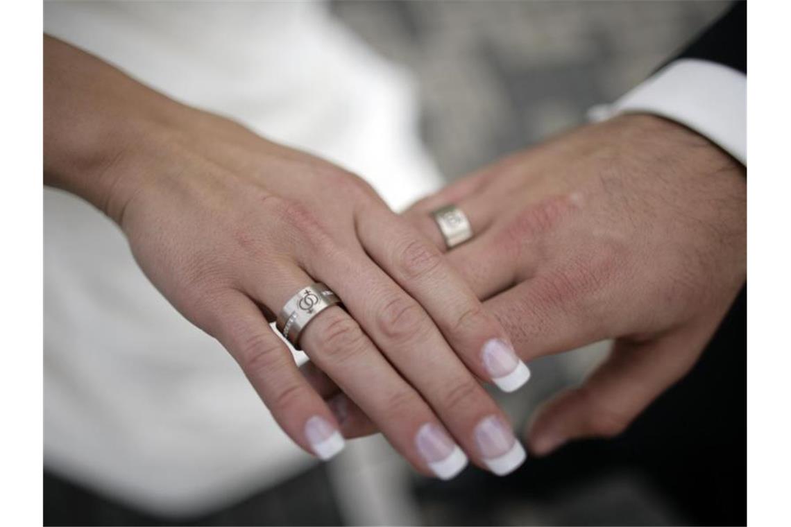 Zwei frisch Vermählte legen nach der Trauung die Hände übereinander. Foto: Jörg Carstensen/dpa/Symbolbild