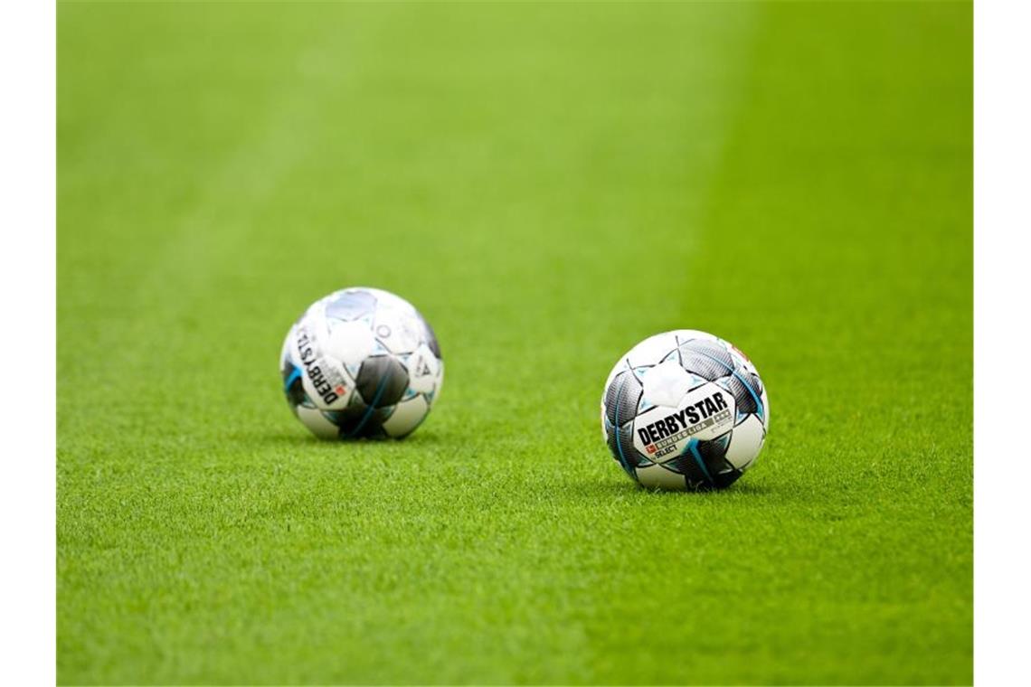 Coronavirus: Hoffenheim gegen Hertha vor leeren Rängen Zwei Fußbälle auf dem Rasen. Foto: Tobias Hase/dpa/Symbolbild