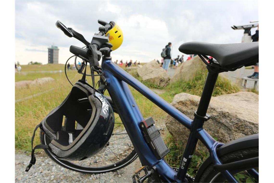 Branche: Lieferengpass bei Fahrrädern verschärft sich Zwei Helme hängen an einem Fahrrad, das auf dem Brocken steht. Foto: Matthias Bein/dpa-Zentralbild/dpa
