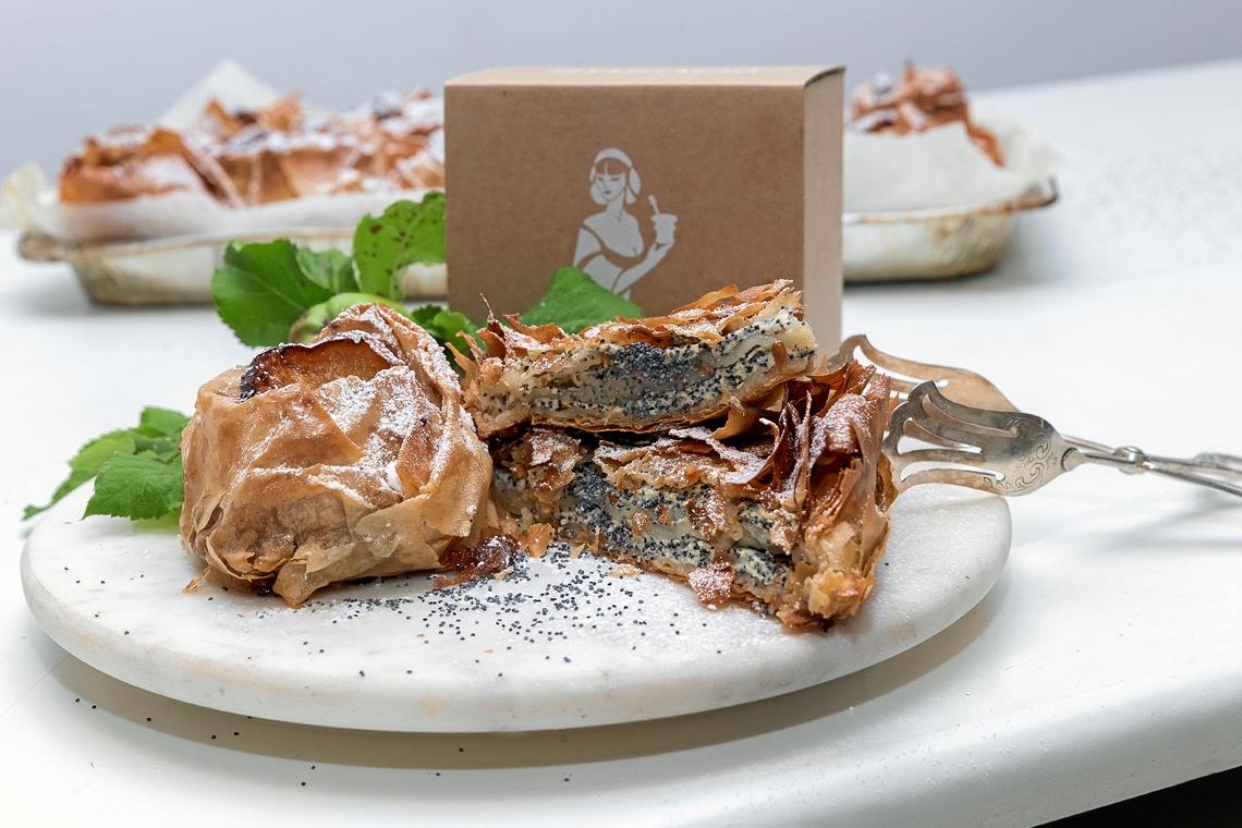 Zwei ihrer handgebackenen Klassiker – Apfel-Zimt- und Mohn-Quark-Strudel. Ihre Kreationen sind nach altem bulgarischen Familienrezept hergestellt, aber modern interpretiert, wie sie sagen. Zum Firmenlogo gehört die heilige Barbara, deren Schwert durch einen Mörser als traditionelles Küchengerät ersetzt ist.