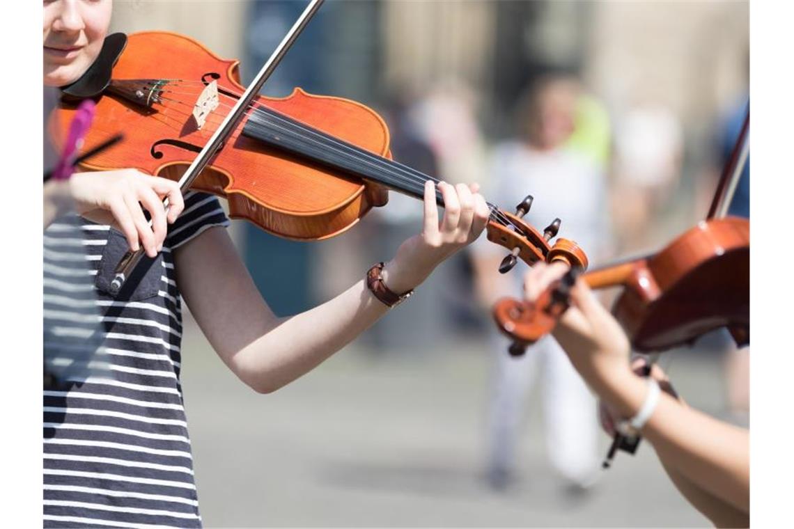 Zwei junge Frauen musizieren auf ihren Geigen. Foto: Mohssen Assanimoghaddam/dpa/Symbolbild