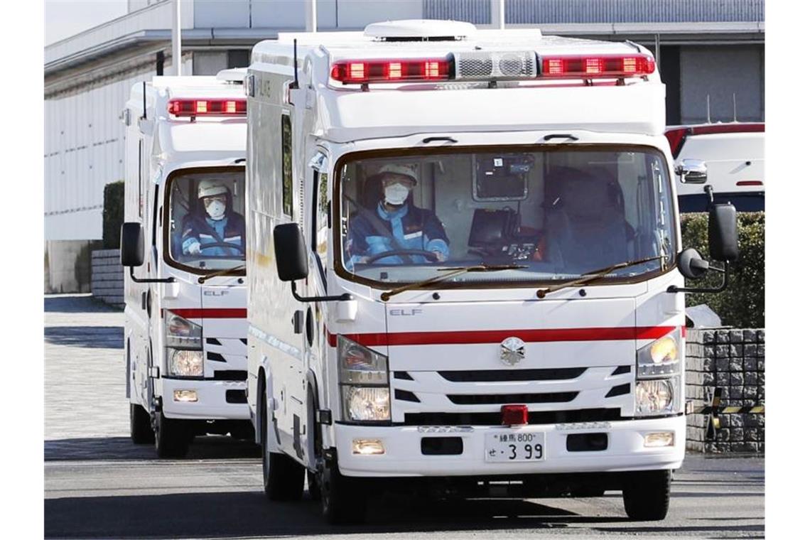 Zwei Krankenwagen verlassen den internationalen Flughafen Haneda in Japan, nachdem eine Chartermaschine der Regierung Personen aus dem chinesischen Wuhan zurückholte. Foto: -/kyodo/dpa