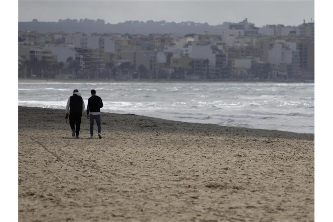 Buchungsboom für Mallorca nach Ende der Reisewarnung Zwei Männer gehen am Strand von Arenal über den Sand. Foto: Clara Margais/dpa