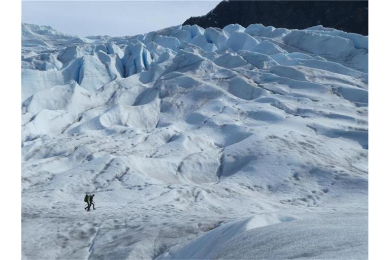 Zwei Menschen wandern auf einem Gletscher in Alaska. Foto: Becky Bohrer/AP/dpa