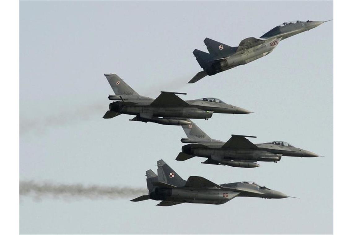 Zwei Mig 29 der polnischen Luftwaffe aus russischer Produktion fliegen über und unter zwei F-16-Kampfjets der polnischen Luftwaffe aus amerikanischer Produktion. Foto: Alik Keplicz/AP/dpa
