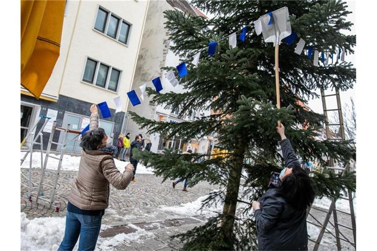 Zwei Mitglieder der sogenannten „Trommlerwieber“ schmücken einen der zukünftigen „Fasnetsbäume“. Foto: Philipp von Ditfurth/dpa