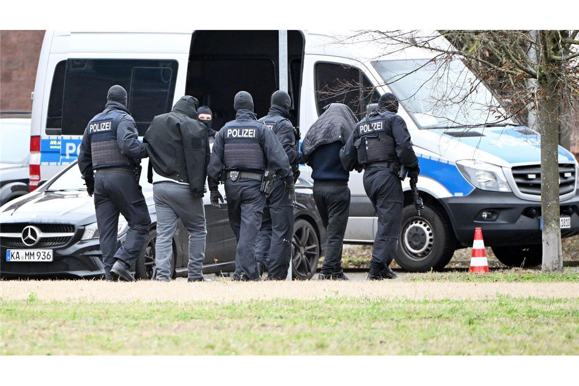 Zwei mutmaßliche Hamas-Mitglieder werden von Polizisten bei einem Hubschrauberlandeplatz von einem Hubschrauber zu einem Auto geführt. (Archivbild)