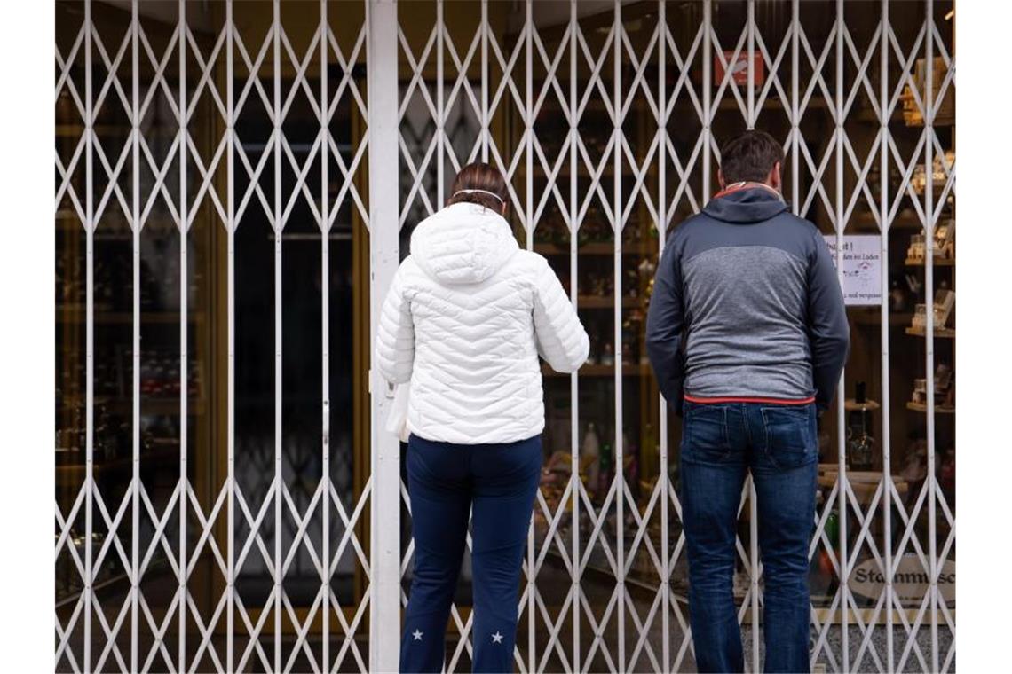 Zwei Passanten stehen in einer Fußgängerzone vor einem geschlossenen Geschäft. Foto: Sven Hoppe/dpa/Symbolbild