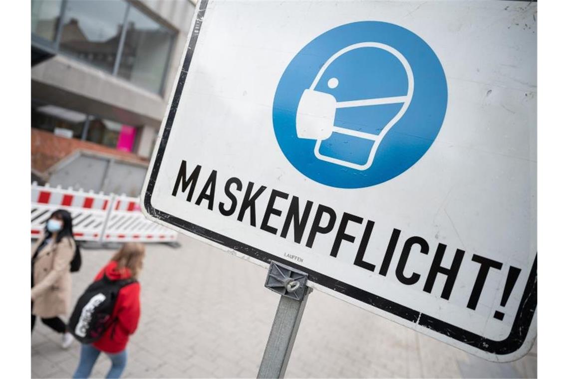 Zwei Passantinnen in der Heilbronner Fußgängerzone hinter einem Maskenpflicht-Hinweisschild. Foto: Sebastian Gollnow/dpa/Archivbild