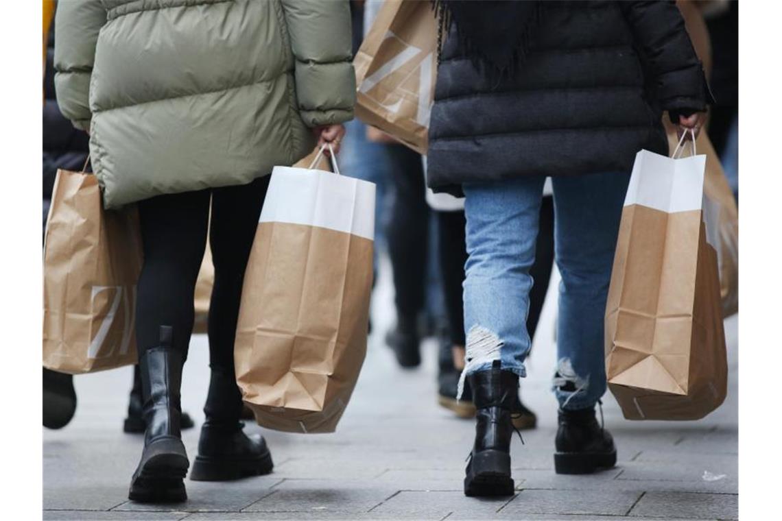 Hemdenhersteller Olymp legt trotz Marktspannungen leicht zu Zwei Personen mit Einkaufstüten. Foto: Martin Gerten/dpa