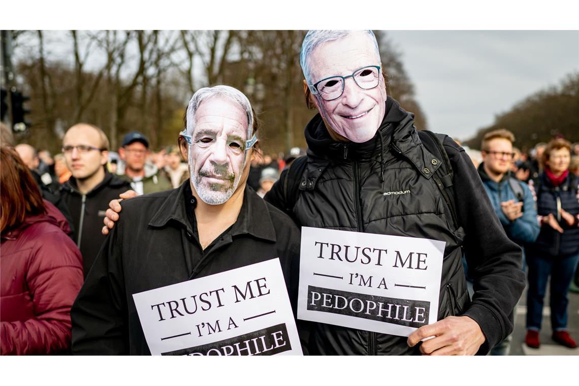 Zwei Personen nehmen an der Demonstration „Transparenz, Rechtsstaat und Schutz von Minderjährigen” mit einer Maske von Jeffrey Epstein (l) und Bill Gates mit einem Schild mit der Aufschrift „Trust me I‘m a pedophile“ teil.