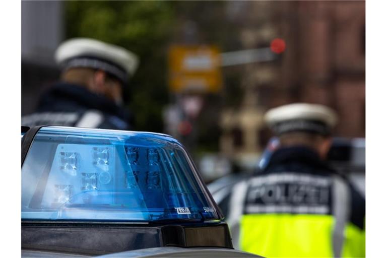 Zwei Polizeibeamte stehen zwischen zwei Einsatzfahrzeugen der Polizei. Über Pfingsten gibt es eine Vielzahl von Demonstrationen in Berlin. Zwei große Veranstaltungen wurden von der Polizei verboten - nun hat das Oberverwaltungsgericht dazu entschieden. Foto: Philipp von Ditfurth/dpa