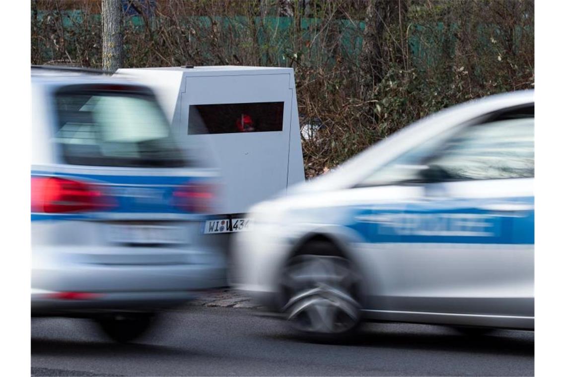 Zwei Polizeiwagen fahren. Foto: Bernd von Jutrczenka/dpa