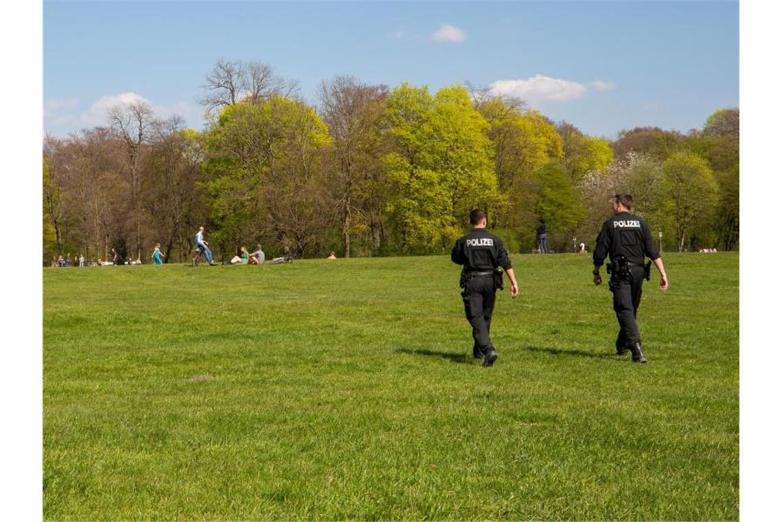 Zwei Polizisten gehen durch den Englischen Garten in München. Foto: Peter Kneffel/dpa