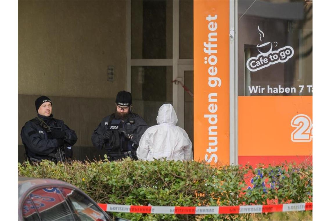 Zwei Polizisten und die Spurensicherung stehen am Tatort im Hanauer Stadtteil Kesselstadt. Foto: Andreas Arnold/dpa