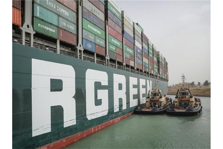 Zwei Schlepperboote versuchen, das im Suezkanal festsitzende Containerschiff „Ever Given“ freizulegen. Foto: -/Suez Canal Authority/dpa