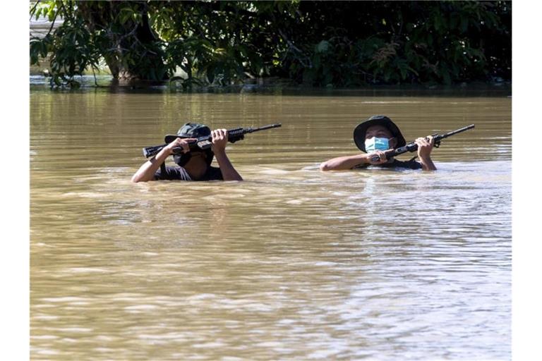 Zwei Soldaten waten durch eine überflutete Straße. Foto: Zulkarnain Kamaruddin/BERNAMA/dpa