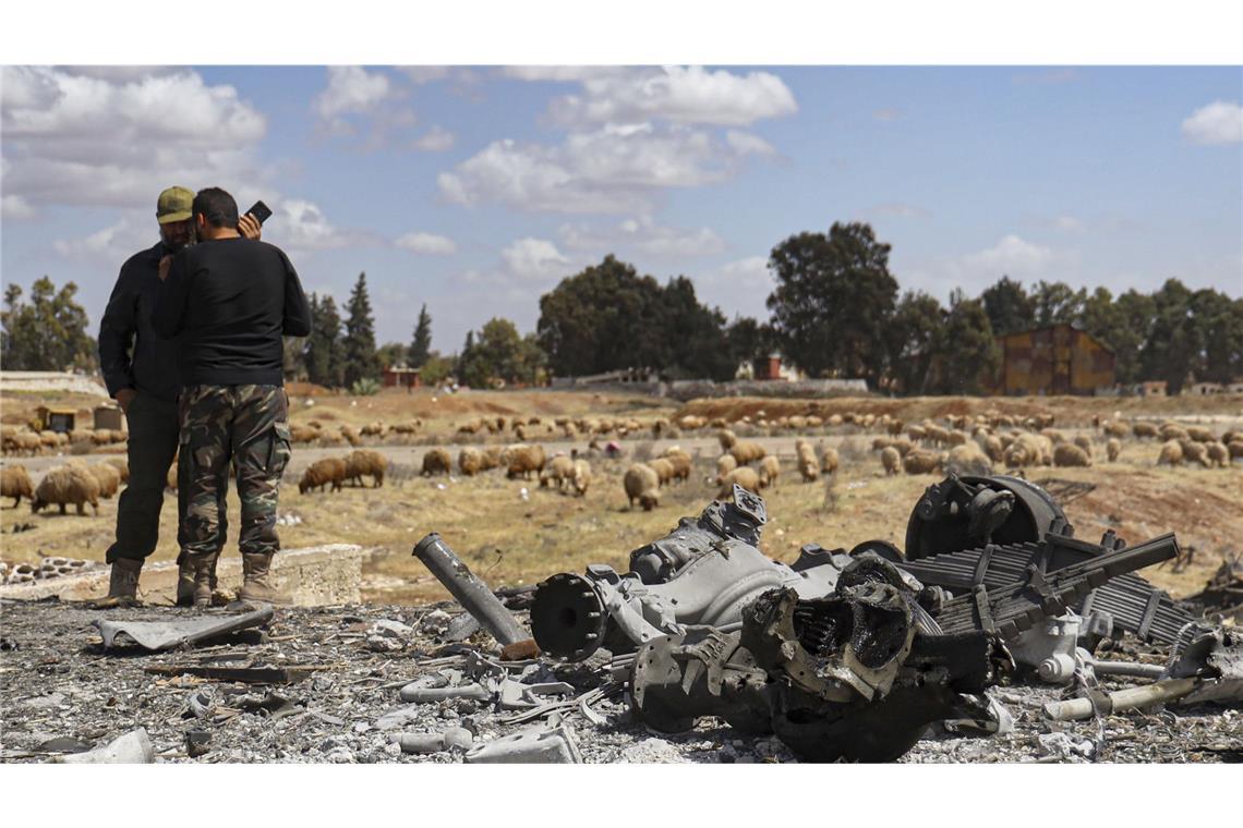 Machtkampf zwischen Israel und Türkei in Syrien Zwei syrische Armeeoffiziere inspizieren den Ort eines israelischen Angriffs auf einen Militärflughafen in der Nähe von Hama.