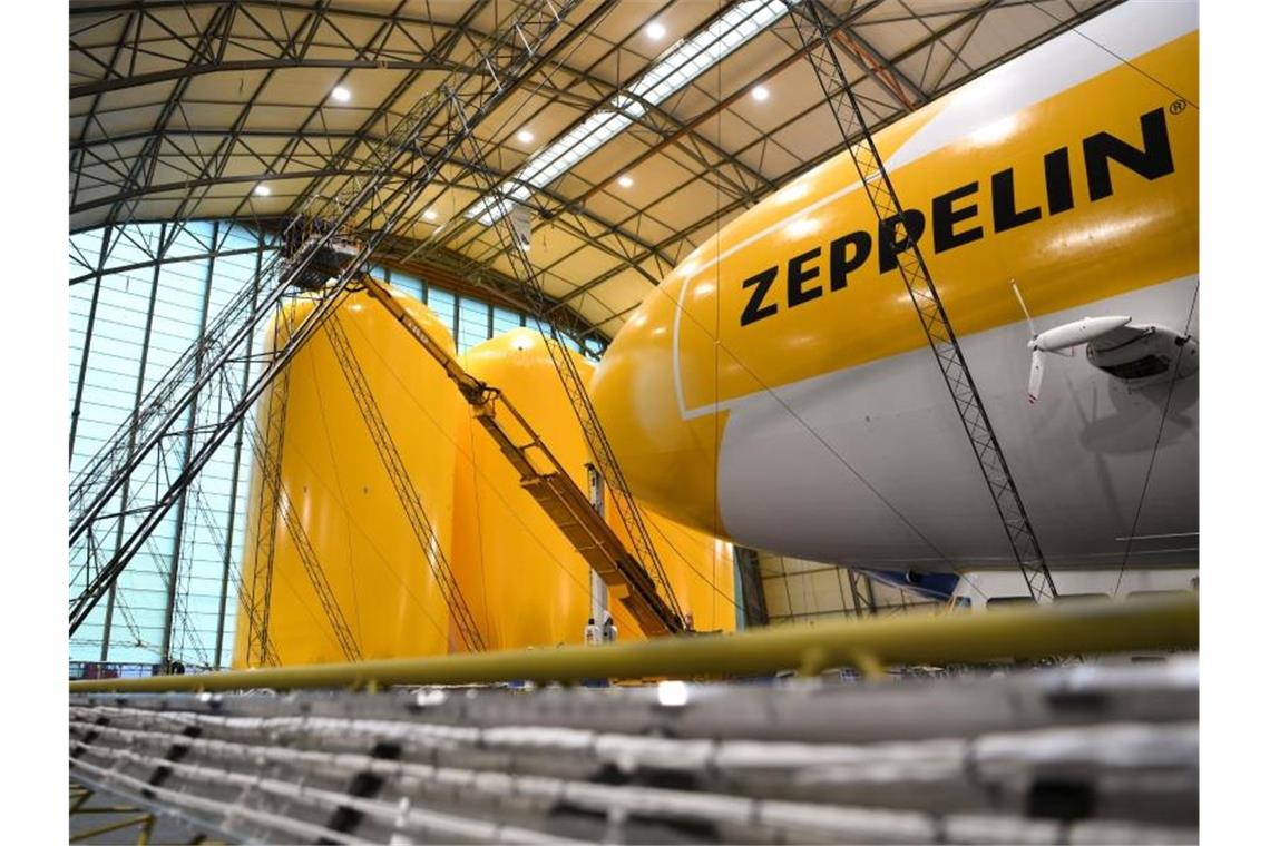 Zwei Techniker arbeiten auf einer Hebebühne an einem Zeppelin NT (Neue Technik). Foto: Felix Kästle/dpa/Archivbild