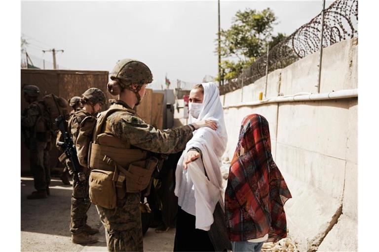 Zwei Zivilisten werden während einer Evakuierung am Hamid Karzai International Airport durch einen Kontrollpunkt geführt. Foto: Staff Sgt. Victor Mancilla/U.S. Marine Corps/AP/dpa