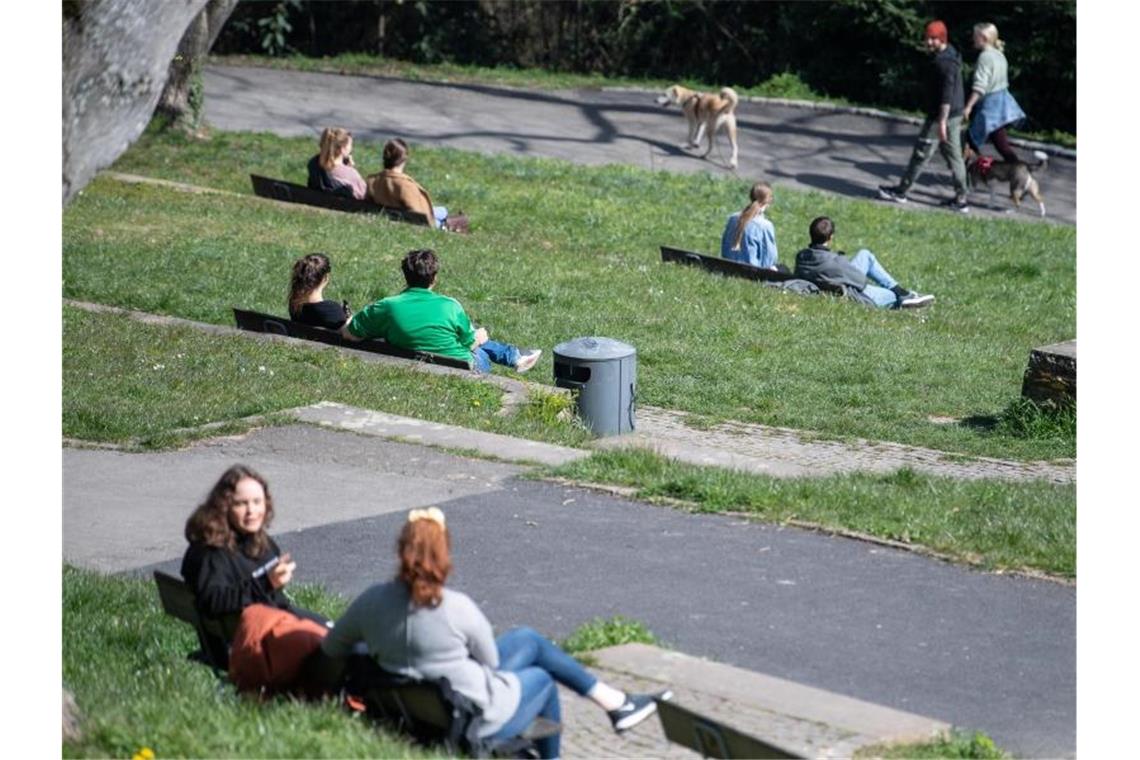 Private Treffen nehmen seit Ostern wieder zu Zweiergruppen sitzen in einem Park. Foto: Sebastian Gollnow/dpa/Archivbild