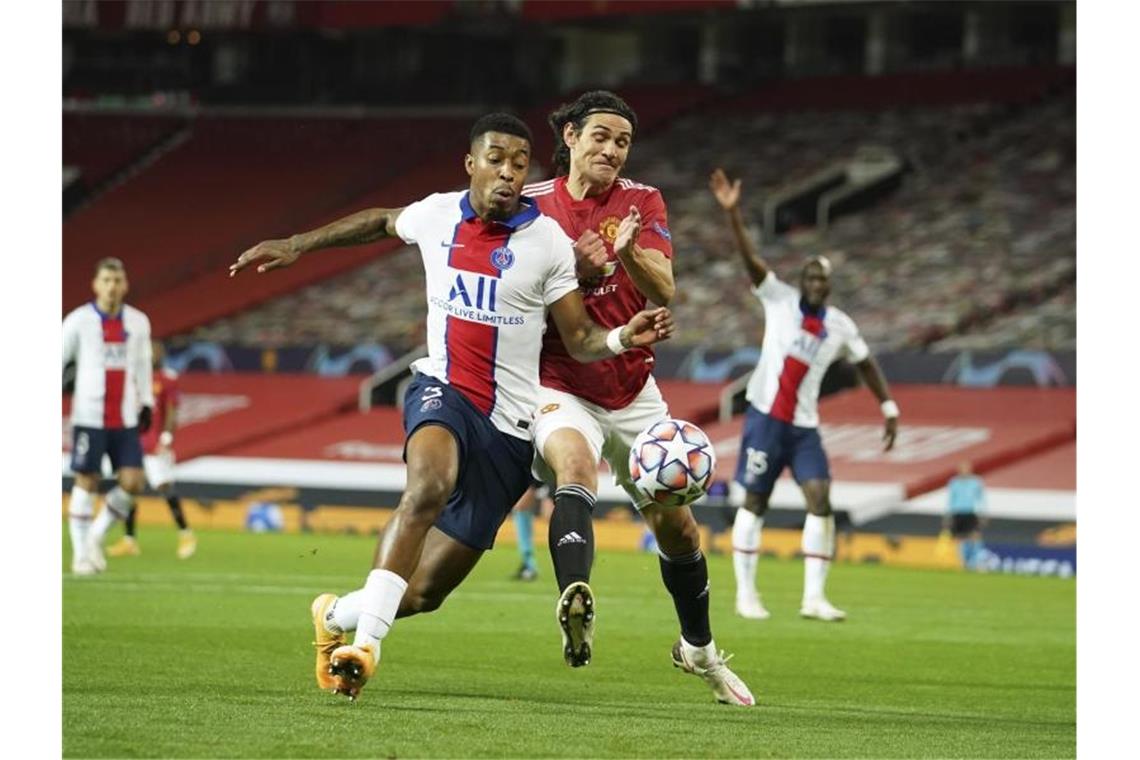 Zweikampf um den Ball zwischen Edinson Cavani (r) von Manchester United und Presnel Kimpembe von Paris Saint-Germain. Foto: Dave Thompson/AP/dpa