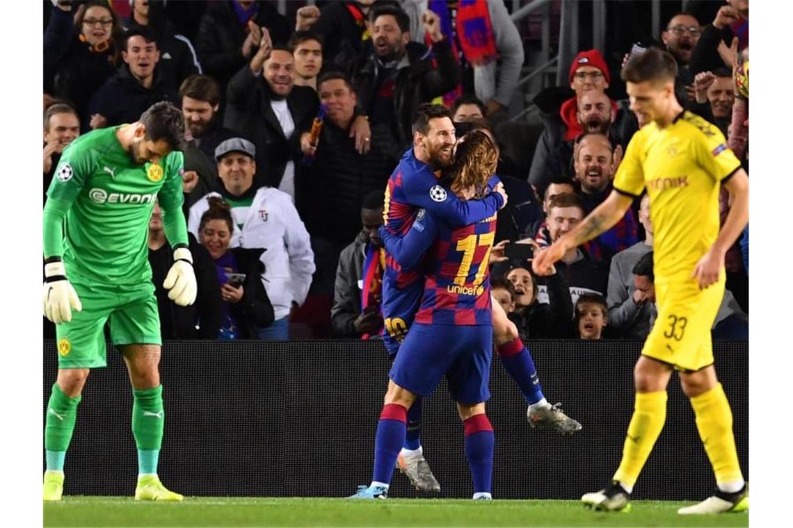 Zwischen Dortmunds geschlagenem Torhüter Roman Bürki (l) und Julian Weigl (r) feiert Lionel Messi (M) seinen Treffer zum 2:0 für den FC Barcelona mit Antoine Griezmann. Foto: Marius Becker/dpa