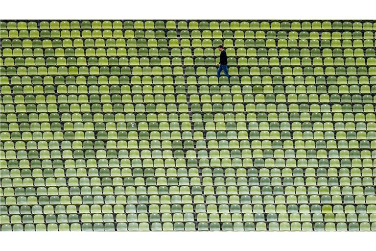 Zwischen leeren Rängen –  Ein Mann geht durchs Olympiastadion