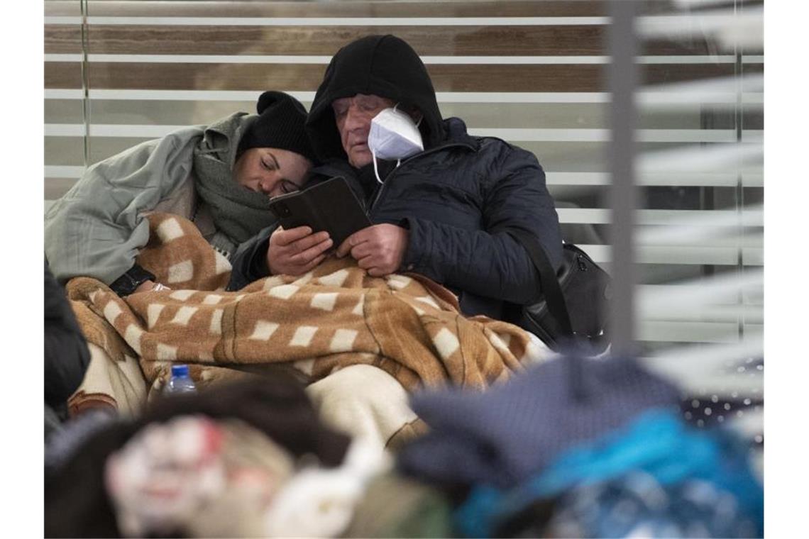 Rund 37.800 ukrainische Flüchtlinge in Deutschland Zwischen Reisetaschen sitzend warten aus der Ukraine geflüchtete Menschen am Sonntagmorgen am Berliner Hauptbahnhof auf ihre Weiterreise. Foto: Paul Zinken/dpa