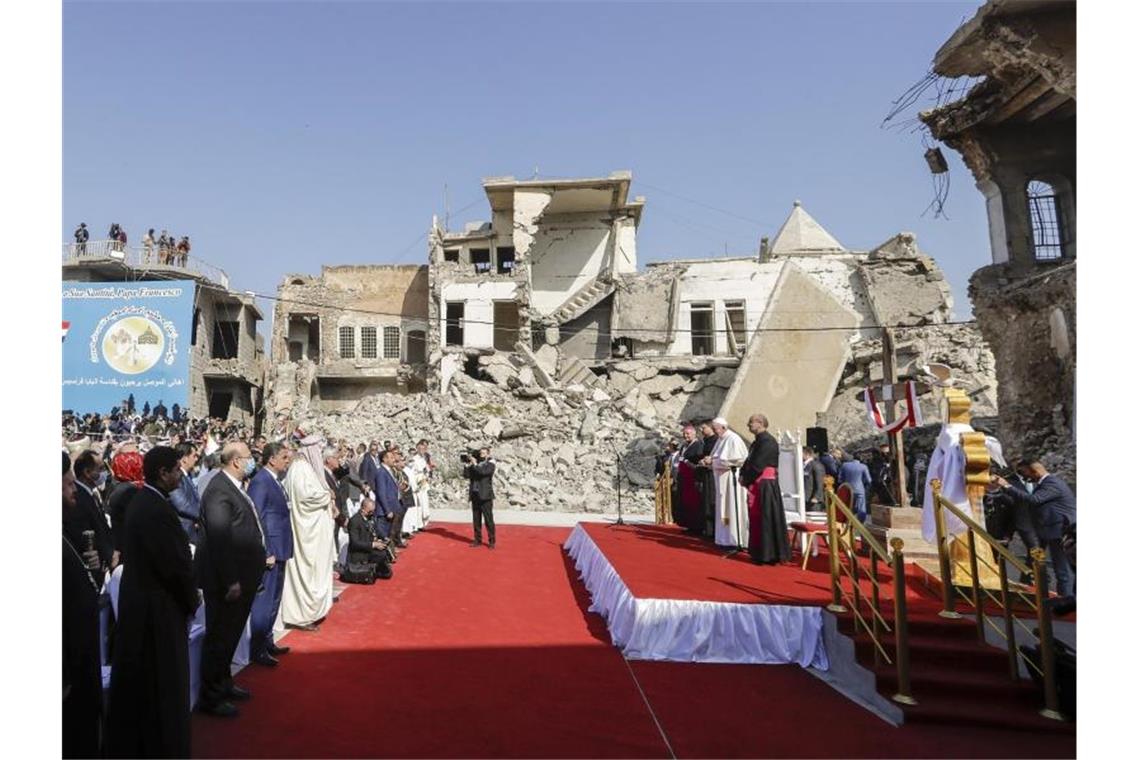 Zwischen von Granaten zerstörten Gebäuden nimmt Papst Franziskus an einem Gebet für die Opfer des Krieges teil. Foto: Andrew Medichini/AP/dpa